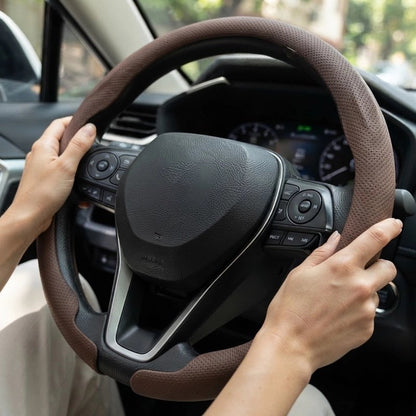 Couvre volant gris et main sur le volant